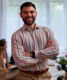 Confident,Businessman,Standing,With,Arms,Crossed,In,A,Modern,Office